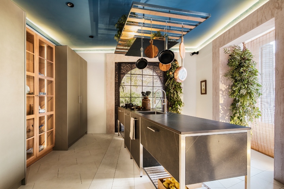 Espacio Delamora reinventó una cocina in & out con madera, acero  y plantas verdes.