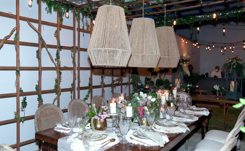 Decoración eco moda elegante y armónica llena de pequeñas luces, velas, follaje y una mampara de madera