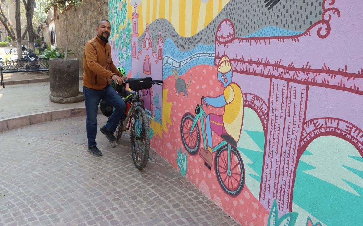 El fotógrafo Atonatiuh Bracho, deteniendo la marcha en un mural del centro histórico de Tequisquiapan. (Cortesía)