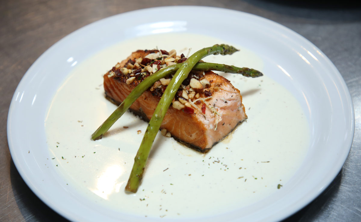 Salmón en crema de champaña con pesto de arándanos y rosas