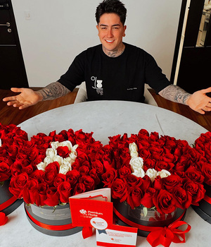 El reconocido influencer Omahi posa junto a un diseño exclusivo de PremiumFlorist, formando el nombre de su novia.