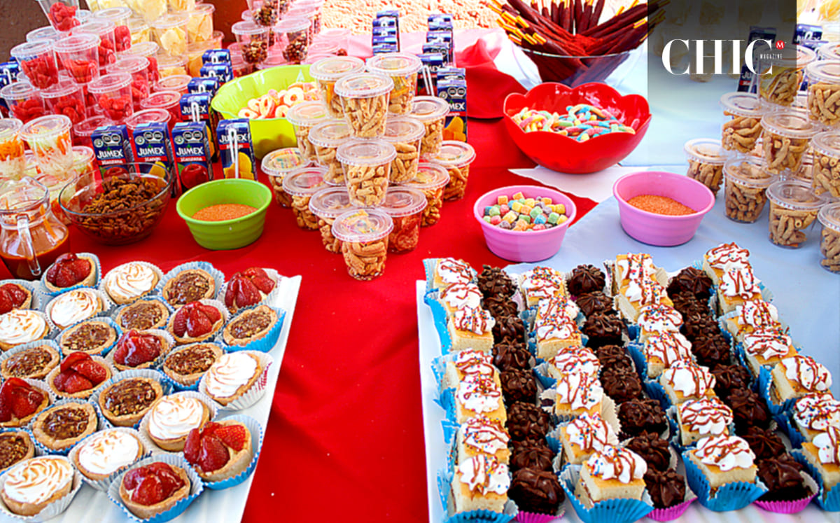 Una mesa llena de postres como frituras, fruta, cupcakes formó parte del evento