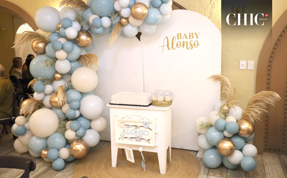 Las más de 40 invitadas fueron recibidas por un back decorado con globos en tonos azul, dorado y blanco, acompañado de la frase Baby Alonso